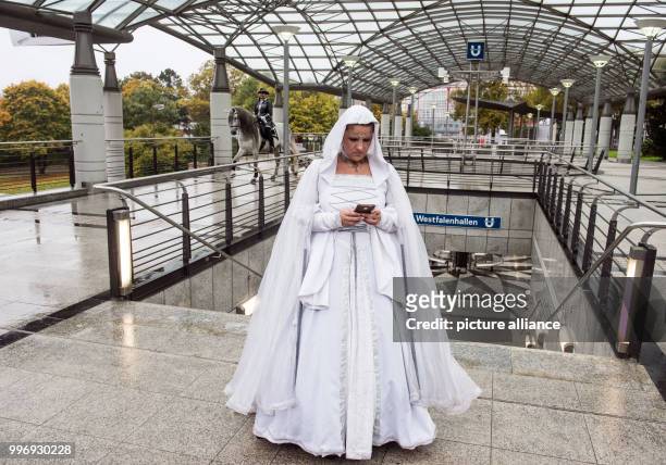 Sandra Olasz from a Spanish riding group looking at her smartphone at an underground station during a photo session of the fair "Hund & Pferd" in...