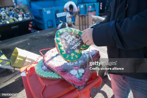 Showman removing the foil from a gingerbread heart in order to dispose of the constituents in their respective garbage bins in Stuttgart, Germany, 05...