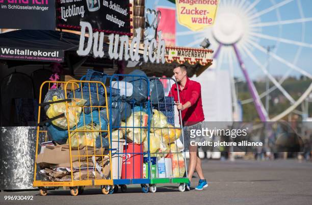 Showman pushing garbage past a kiosk at the Cannstatt Volksfest in Stuttgart, Germany, 05 October 2017. About four to five tons of garbage are...