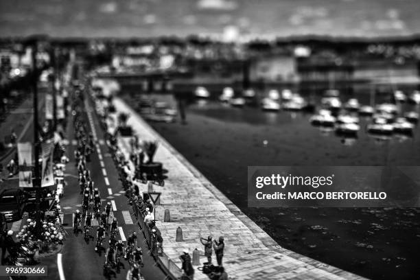 Photo taken with a tilt and shift lens shows the pack riding along the harbour of Concarneau, western France, during the fifth stage of the 105th...