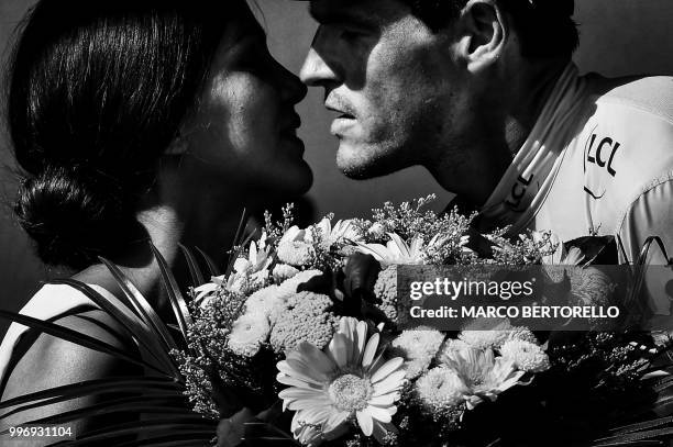 Belgium's Greg Van Avermaet, wearing the overall leader's yellow jersey, kisses a hostess on the podium after the fifth stage of the 105th edition of...