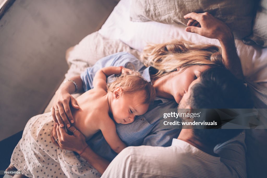 眠っている赤ちゃんのベッドでキスを愛するカップル