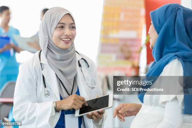 cheerful doctor meets with patient - pregnant muslim stock pictures, royalty-free photos & images