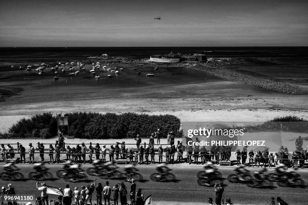 Spectators watch the pack ride along the coastline past the Keragan Fort, or Fort-Bloque in Ploemeur, during the fifth stage of the 105th edition of...