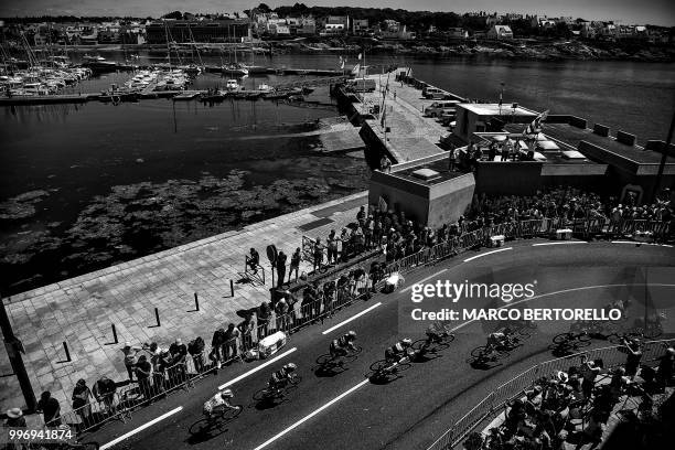 The pack rides along the harbour of Concarneau, western France, during the fifth stage of the 105th edition of the Tour de France cycling race...