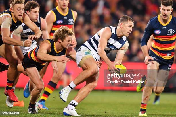 Joel Selwood of the Cats is tackled by Rory Sloane of the Crows during the round 17 AFL match between the Adelaide Crows and the Geelong Cats at...