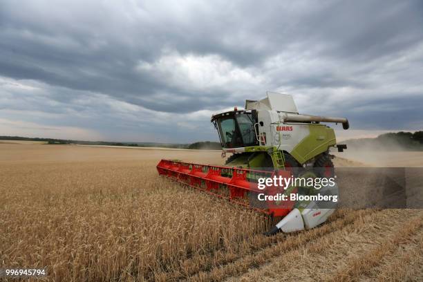 Tucano combine harvester, manufactured by Claas KGaA, drives through a field of wheat during the summer harvest on a farm operated by Ros Agro Plc,...