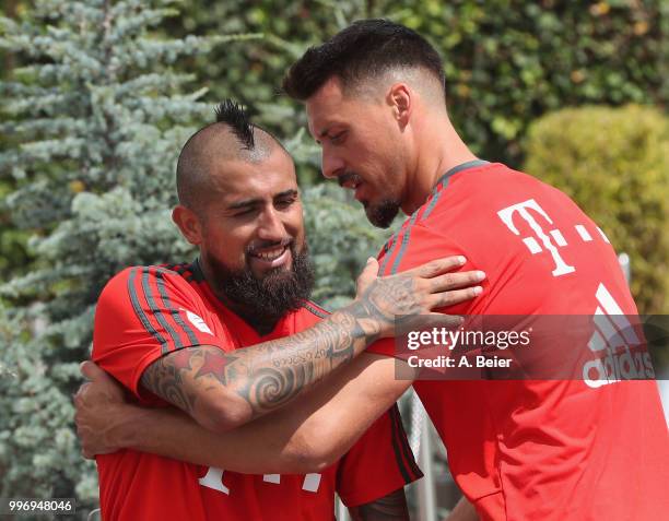 Arturo Vidal of FC Bayern Muenchen is hugged by his teammate Sandro Wagner after a training session at the club's Saebener Strasse training ground on...