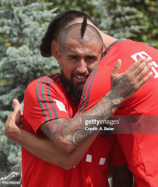 Arturo Vidal of FC Bayern Muenchen is hugged by his teammate Sandro Wagner after a training session at the club's Saebener Strasse training ground on...