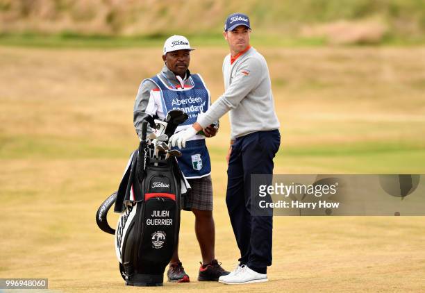 Julien Guerrier of France and his caddy select a club on hole eighteen during day one of the Aberdeen Standard Investments Scottish Open at Gullane...