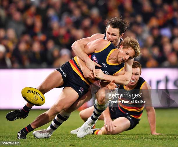 Patrick Dangerfield of the Cats tackles Rory Sloane of the Crows during the round 17 AFL match between the Adelaide Crows and the Geelong Cats at...
