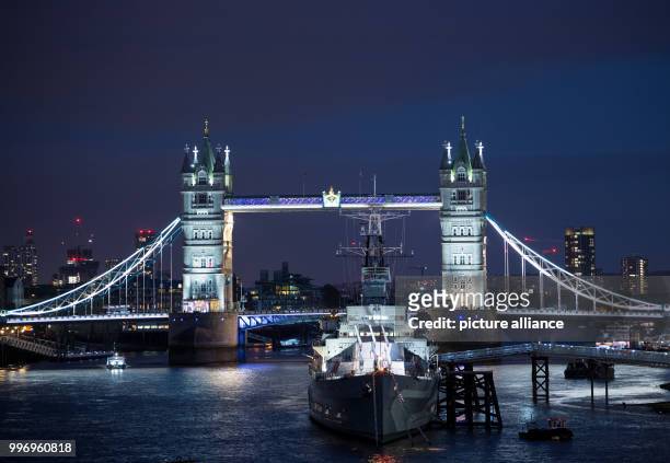 View of the river Thames and the illuminated Tower Bridge in London, England, 3 October 2017. In the front the former British war ship HMS Belfast...