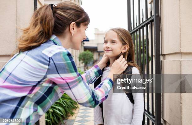 woman talking with daughter outside school gate - school building entrance stock pictures, royalty-free photos & images