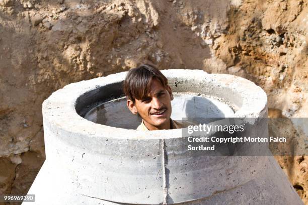 man cleaning tandoor oven - tandoor oven stock pictures, royalty-free photos & images