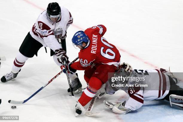 Tomas Rolinek of Czech Republic is challenged by Lauris Darzins and goalkeeper Edgars Masalskis of Latvia during the IIHF World Championship group F...