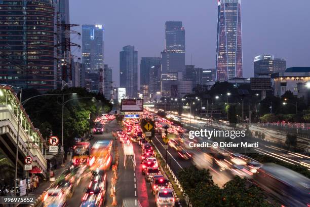 rush hour traffic captured with long exposure along the gatot subroto highway in the heart of jakarta business district in indonesia - didier marti stock pictures, royalty-free photos & images