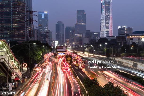 rush hour traffic captured with long exposure along the gatot subroto highway in the heart of jakarta business district in indonesia - newly industrialized country stock pictures, royalty-free photos & images