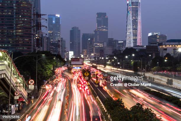 rush hour traffic captured with long exposure along the gatot subroto highway in the heart of jakarta business district in indonesia - tillväxtmarknad bildbanksfoton och bilder