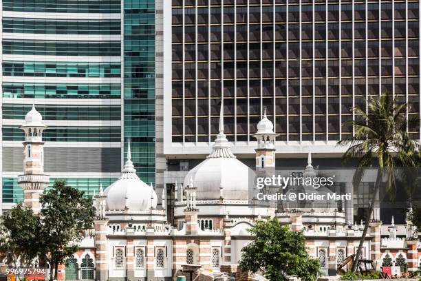 the friday mosque, or masjid jamek, in front of bank buildings in kuala lumpur, malaysia capital city - masjid jamek stockfoto's en -beelden