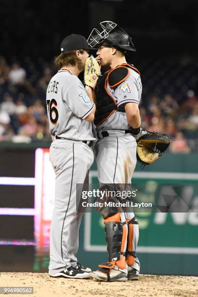 Dillon Peters of the Miami Marlins talks with J.T. Realmuto on the mound during a baseball game against the Washington Nationals at Nationals Park on...