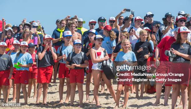 Hundreds look on as Newport Beach lifeguard boats make a pass by the Junior Lifeguard Headquarters in Newport Beach as they celebrate Ben Carlson Day...