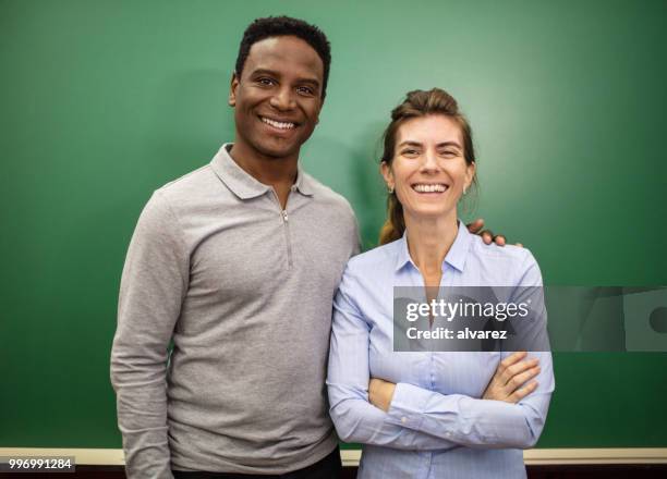 lachende docenten permanent tegen blackboard - two female teachers blackboard stockfoto's en -beelden