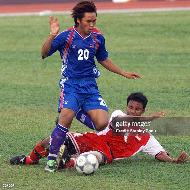 Wuttiya Yongant of Thailand is checked by Ratna Suffian of Singapore during a Group A match between Thailand and Singapore held at the MPPJ Stadium,...