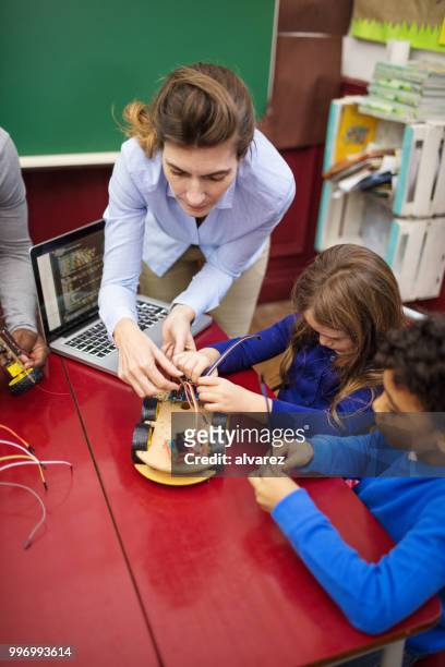 insegnante che assiste gli studenti nella realizzazione di un'auto giocattolo - ricerca di scienze foto e immagini stock