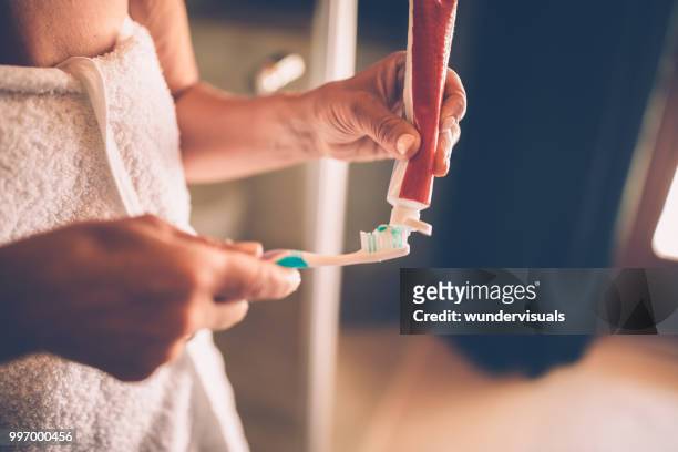 primer plano de mujer madura a cepillar sus dientes - lavarse los dientes fotografías e imágenes de stock
