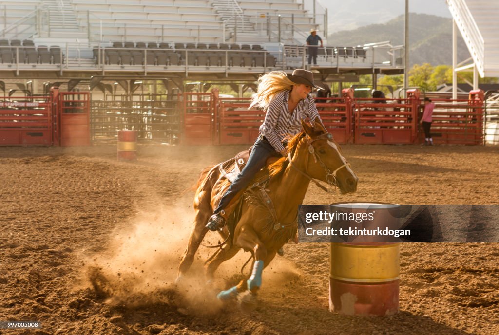 Cowgirl cowboy riding horse at rodeo paddock arena at nephi of Salt lake City SLC Utah USA