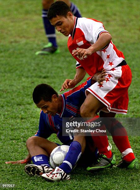 Sarawut Trephan of Thailand is fouled by Razali Bin Johari of Singapore during a Group A match between Thailand and Singapore held at the MPPJ...