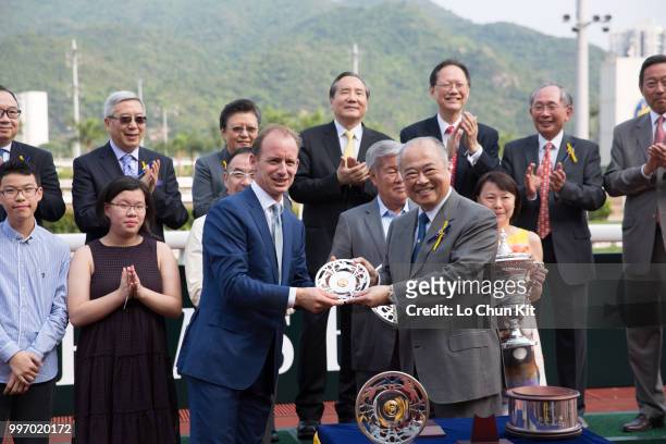At the trophy presentation ceremony, HKJC Steward The Hon Sir C K Chow presents the Sprint Cup silver dishes to Dundonnell’s trainer Richard Gibson...