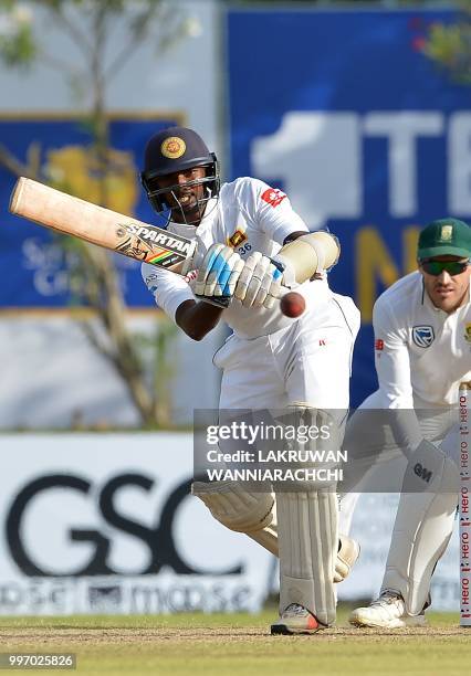 Sri Lankan cricketer Lakshan Sandakan plays a shot as South Africa's Faf du Plessis looks on during the first day of the opening Test match between...