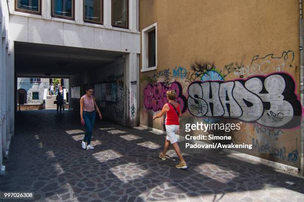 Tourists and students walk in Calle Contarina, along the Ca' Foscari University, through Dorsoduro district, on July 12, 2018 in Venice, Italy. The...