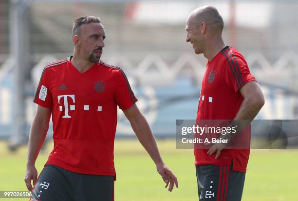 Franck Ribery and Arjen Robben of FC Bayern Muenchen chat during a training session at the club's Saebener Strasse training ground on July 12, 2018...