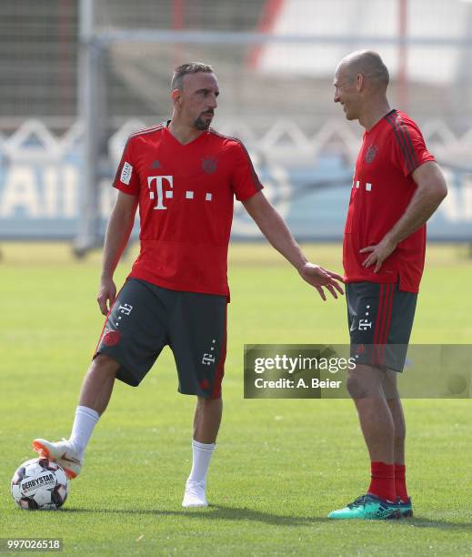 Franck Ribery and Arjen Robben of FC Bayern Muenchen chat during a training session at the club's Saebener Strasse training ground on July 12, 2018...