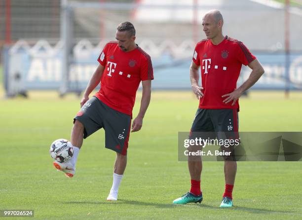 Franck Ribery and Arjen Robben of FC Bayern Muenchen chat during a training session at the club's Saebener Strasse training ground on July 12, 2018...