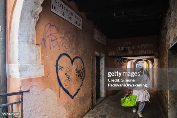 Chef goes to a storage room in the Sotoportego De Le Do Spade, where there are graffiti and tags on the walls, through San Polo district, on July 12,...