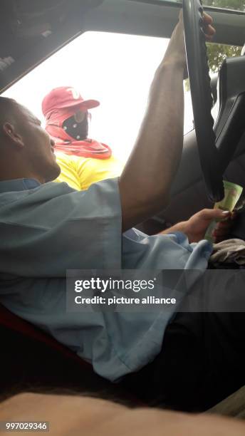 Driver pays road toll to a member of the Wayuu indigenous tribe at the border to Venezuela, in Colombia, 5 September 2017. Many in the region La...