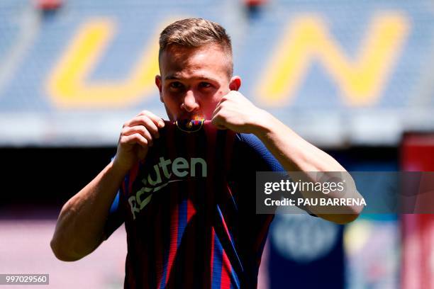 Barcelona's new player Brazilian midfielder Arthur Henrique Ramos de Oliveira Melo kisses his new jersey during his official presentation at the Camp...