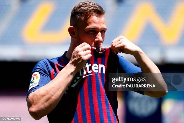 Barcelona's new player Brazilian midfielder Arthur Henrique Ramos de Oliveira Melo kisses his new jersey during his official presentation at the Camp...