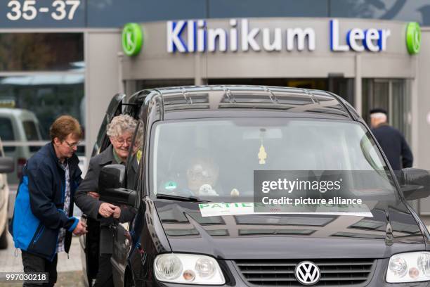 Taxi driver Mrs. Hilbrands helping the patient, Mrs. Busenga, to board the patient mobile in front of the Leer Clinic in Leer, Germany, 04 October...