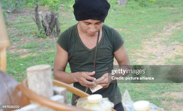Franklin López of the indigenous Wayuu tribe counts the money which he earned selling smuggled petrol in Maicao, Colombia, 5 September 2017. Many in...