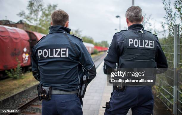 Police officers watch a train with radioactive waste rolls by, at the plattform of the train station in Ochtrup, Germany, 06 October 2017. Activists...