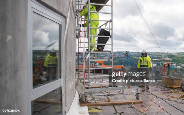 Construction workers mounting anchors for the special outer membrane of the test tower during a press tour on the occasion of the opening of...