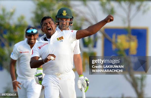 Sri Lankan cricketer Rangana Herath celebrates after he dismissed South Africa's Aiden Markram during the first day of the opening Test match between...