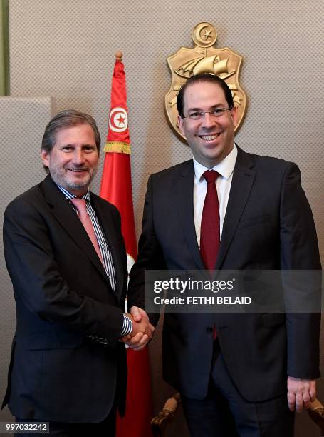 Tunisian prime minister Youssef Chahed shakes hands with the European Commissioner for European Neighbourhood Policy and Enlargement Johannes Hahn ,...