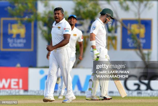 Sri Lankan cricketer Rangana Herath celebrates after he dismissed South Africa's Aiden Markram during the first day of the opening Test match between...
