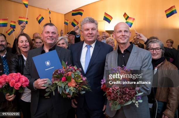 Thomas Niederuhl and Heinz Banziger standing together with Munich Mayor Dieter Reiter for a picture after their marriage ceremony in the civil...