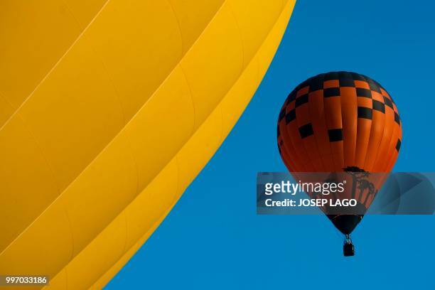 Hot-air balloons fly during the 22th European Balloon Festival in Igualada, near Barcelona on July 12, 2018. - The European Balloon Festival is the...